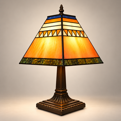 Lampe de Chevet Tiffany Géométrique - VintageLine | Cocon de Lune - allumée sur fond neutre, abat-jour pyramidal en vitrail orange, crème et bleu, pied bronze